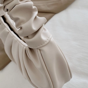 Close-up of fine cloud-like pleat craftsmanship on beige leather shoulder bag
