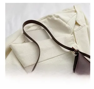 Détail du sac sous l'aisselle en cuir marron avec fermoir doré et bandoulière confortable