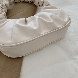 Detailed view of beige pleated shoulder bag showing premium faux leather texture