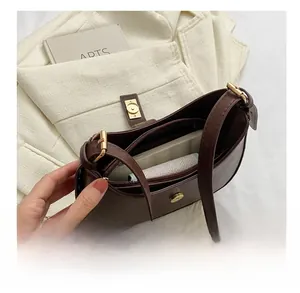 Intérieur du sac sous le bras en similicuir marron avec compartiments à glissière