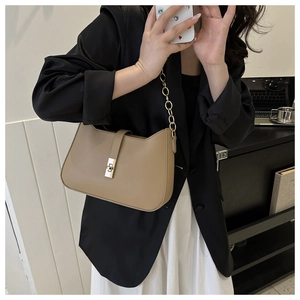 Detail of khaki shoulder bag with fine texture and elegant gold chain strap detail