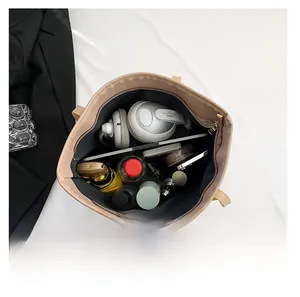 Detailed interior of a beige tote bag showing large capacity for tablet and daily items