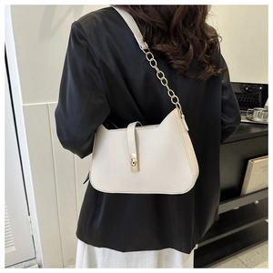 Detail of cream white underarm bag with gold metal buckle and stylish chain strap
