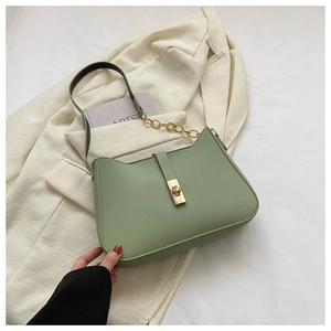 Detail shot of green PU leather shoulder bag featuring golden clasp and chain strap accents