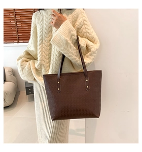 Close-up of quilted coffee brown tote bag with elegant gold rivet handle details