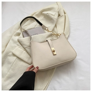 Detail of cream white faux leather underarm bag featuring a elegant gold rectangular metal lock