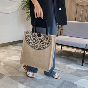 Detailed view of linen tote bag featuring a black mandala pattern and rope handle