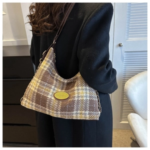 Detailed view of checkered wool hobo bag with leather strap and golden chain accent