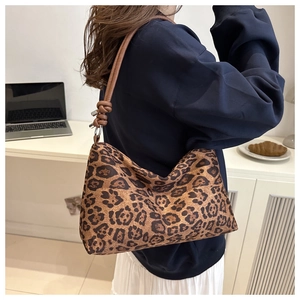 Stylish leopard print shoulder bag for women with brown knotted strap in a cozy home setting