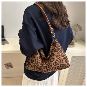 Detail view of large leopard print hobo bag with brown leather strap and knot accent