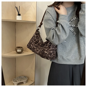 Close-up of leopard print hobo bag with a dark brown knotted strap and metal zipper