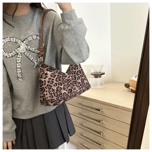 Detail of leopard print shoulder bag with dark brown leather strap and knot accent