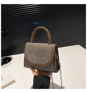 Detailansicht der braunen Wildledertasche mit Strass-Klappe und silberner Kettenriemen