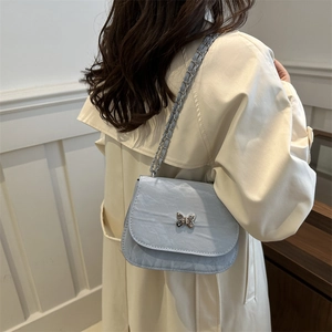 Light blue pleated leather crossbody bag with a silver butterfly buckle and chain strap