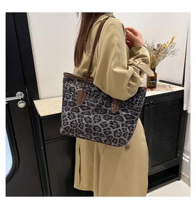 Detail of leopard print tote bag with brown leather handles and high-capacity design