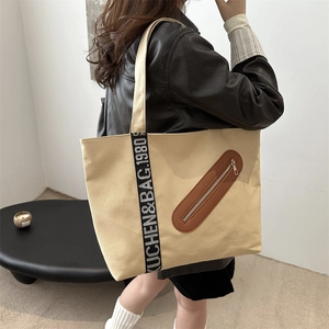 Grand sac cabas en toile beige avec bandoulières lettrées noires et poche zippée en cuir