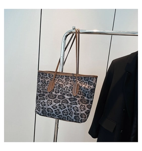 Detail of leopard print tote bag with brown straps on a blazer background