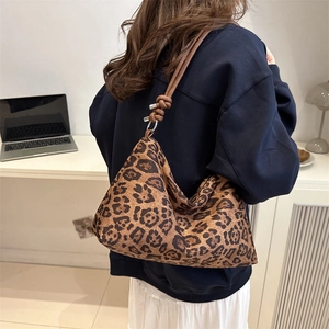 Leopard print hobo shoulder bag with round cord straps shown in a lifestyle setting