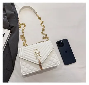 Detailed view of white quilted crossbody bag with gold chain and phone size comparison