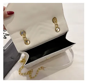 Macro view of white quilted bag's interior space and premium gold chain strap detail