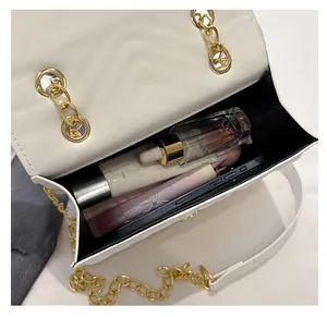 Interior view showing the large capacity of the beige quilted chain bag with cosmetics