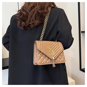 Detailed back view of a beige quilted leather crossbody bag with golden chain and tassel