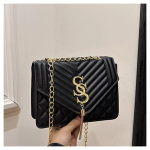 Detail of black quilted leather bag with golden SS logo and metallic fringe tassel