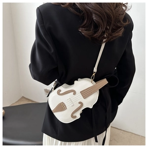 Detail of creative violin-shaped crossbody bag with brown leather patchwork on white body