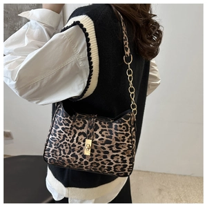 Detail of leopard print shoulder bag with gold chain strap and metal turn-lock closure