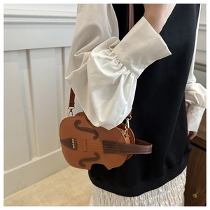 Detail shot of a violin-shaped crossbody bag featuring realistic brown color blocking