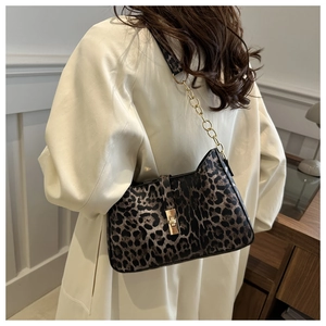 Detail view of leopard print crescent bag with gold buckle and chain shoulder strap