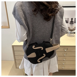 Unique violin-shaped crossbody bag in black PU leather with musical detail on model