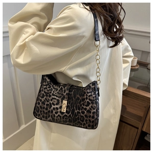 Chic leopard print underarm bag with gold chain strap and buckle on a shoulder model