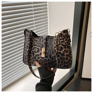 Detail of leopard print crescent bag featuring gold twist lock and metallic chain accents
