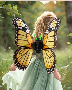 Detail of electric butterfly wings with glowing antennae on child model in garden