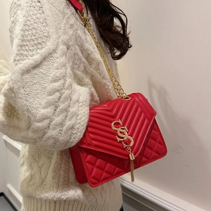 Chic red quilted crossbody bag with gold chain and fringe detail shown on model