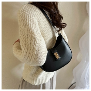 Détail du sac de selle en cuir noir avec une boucle métallique dorée distinctive et élégante