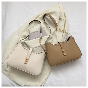 Detailed shot of beige and khaki leather shoulder bags with gold chain straps and metal buckles