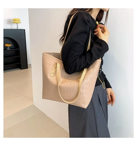 Detail of beige tote bag showing 3D geometric texture and dual shoulder straps