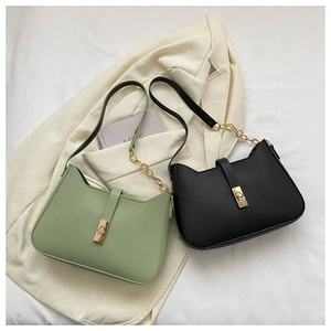Detail of minimalist green and black leather shoulder bags with gold chain straps