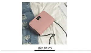 Detailed view of pink leather crossbody bag with black square twist lock on white bedding