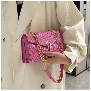 Detail view of rose pink crocodile pattern small square bag with golden U-shaped buckle
