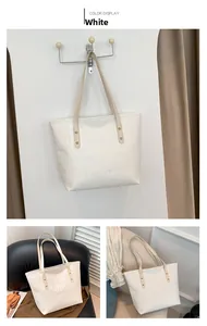 Close-up of white embossed tote bag featuring quilted pattern and durable brown handles