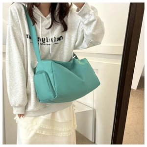 Detail view of mint green nylon crossbody bag showing adjustable wide shoulder strap