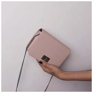Close-up of pink crossbody bag showing texture of leather and metal twist lock