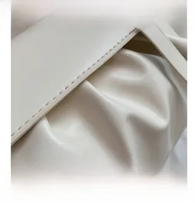 Detail showing high-quality stitching and ruched leather on the cream shoulder bag