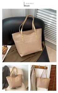Detail of khaki tote bag with diamond lattice pattern and golden rivet accents
