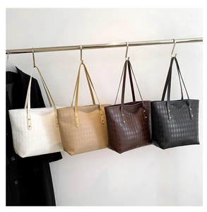 Detailed view of quilted tote bags in four colors hanging on a metal display rack