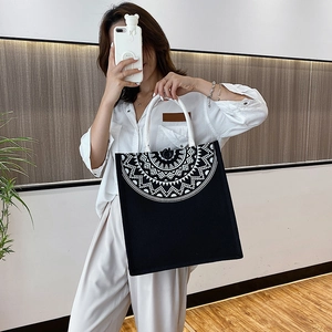 Detail of canvas tote bag with white mandala pattern and thick rope handles for women