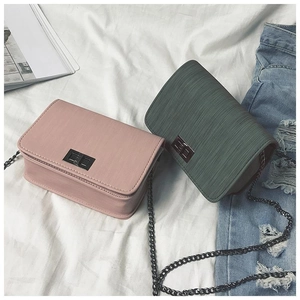 Detail of cross-grain textured small square bags with metal turn-lock and chain straps